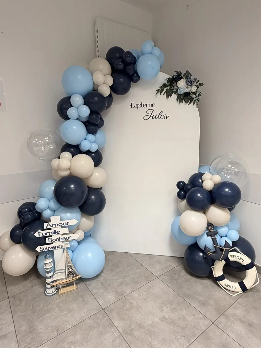 Backdrop de baptême avec arche de ballons bleu marine et panneau personnalisé