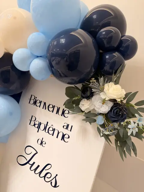 Panneau « Bienvenue au baptême de Jules » avec ballons bleu marine et bleu ciel et bouquet de roses