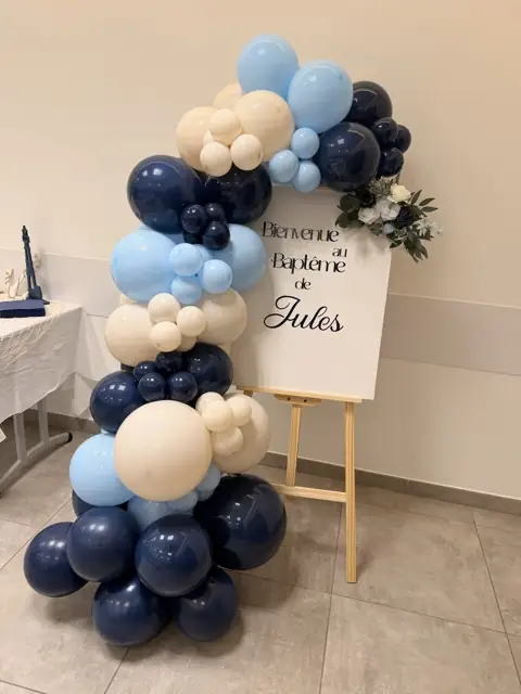 Panneau de bienvenue du baptême de Jules avec guirlande de ballons bleu marine, bleu ciel et sable